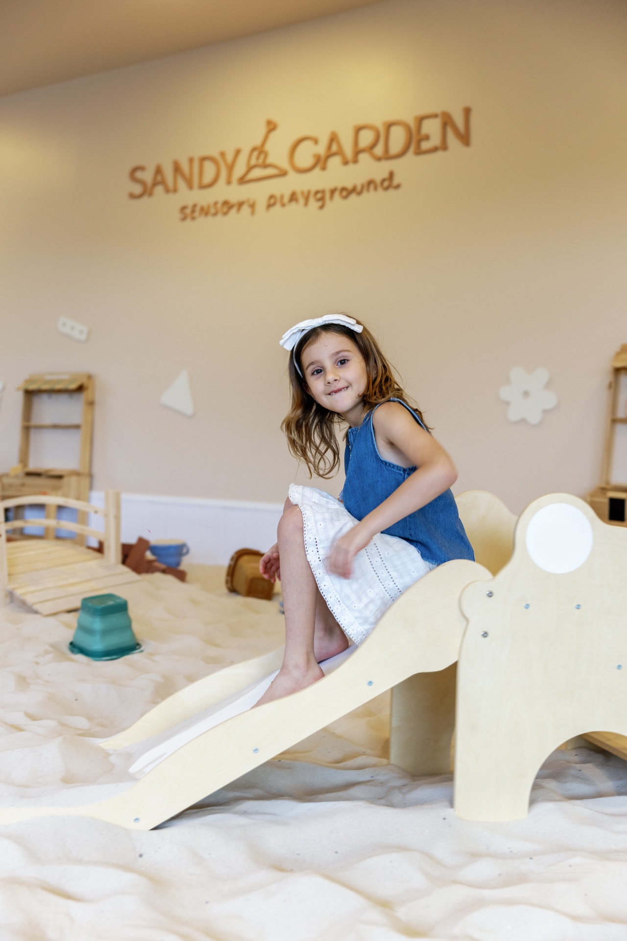 Niña en el tobogán de Sandy Garden